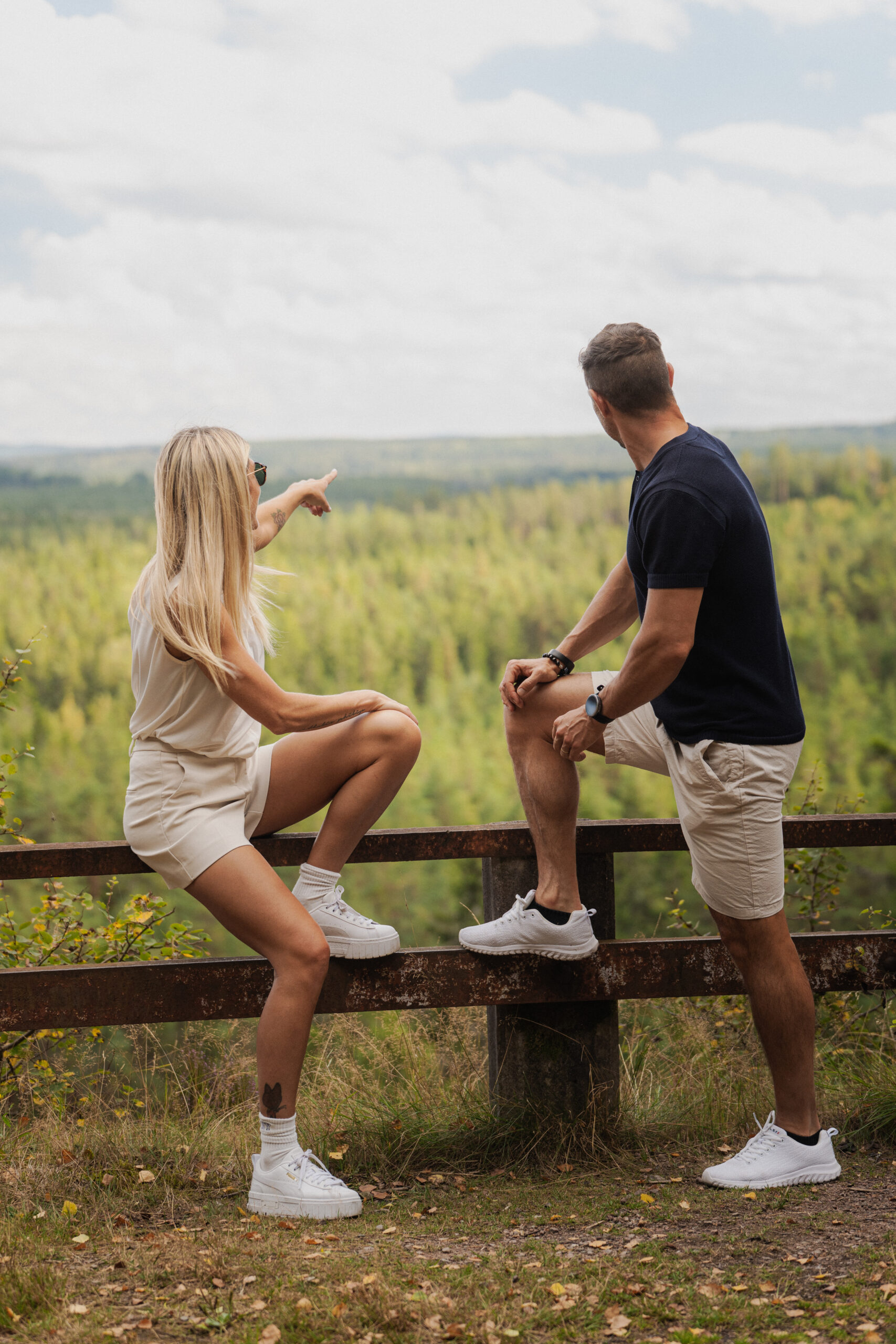 Ett par står på en avsats i Jättestigen på Isaberg och blickar ut över det småländska skogslandskapet.