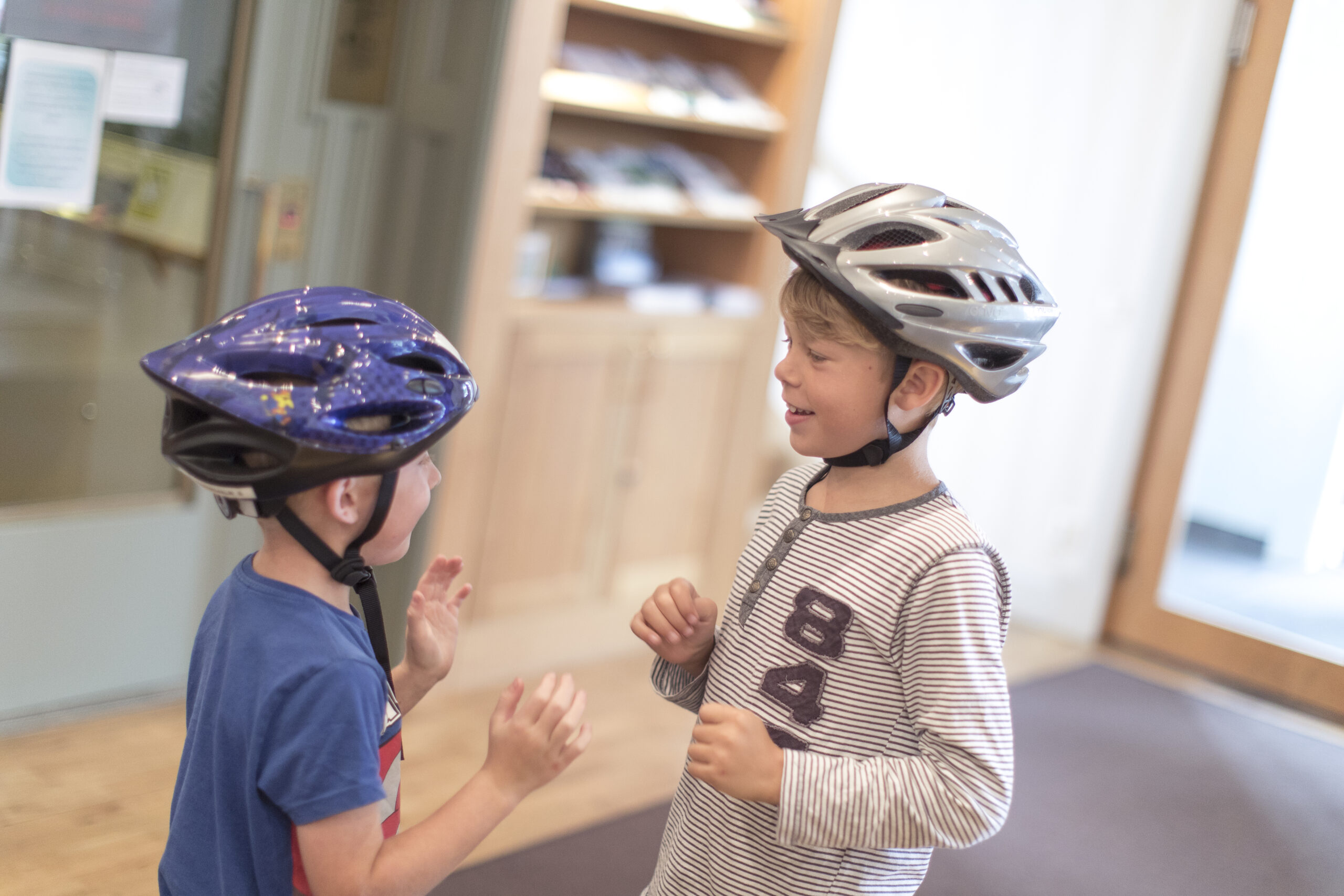Två barn i hjälmar på Hestraviken hotell vid Isaberg, redo för cykeltur i en familjevänlig och naturskön miljö.