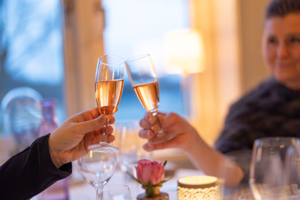 Två som skålar vid bordet med en fördrink som ingår i Smålands-dealen på Hestraviken hotell i Småland.