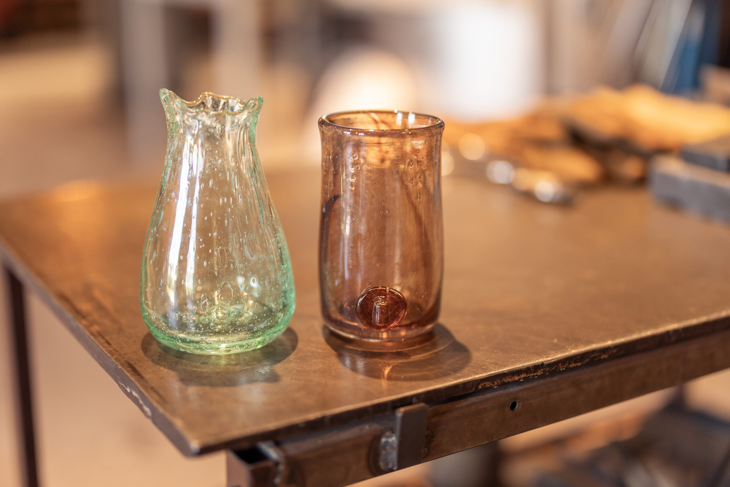 Gäst visar upp sitt egengjorda glas efter en prova-på-glasblåsning på Glasets Hus i Limmared.