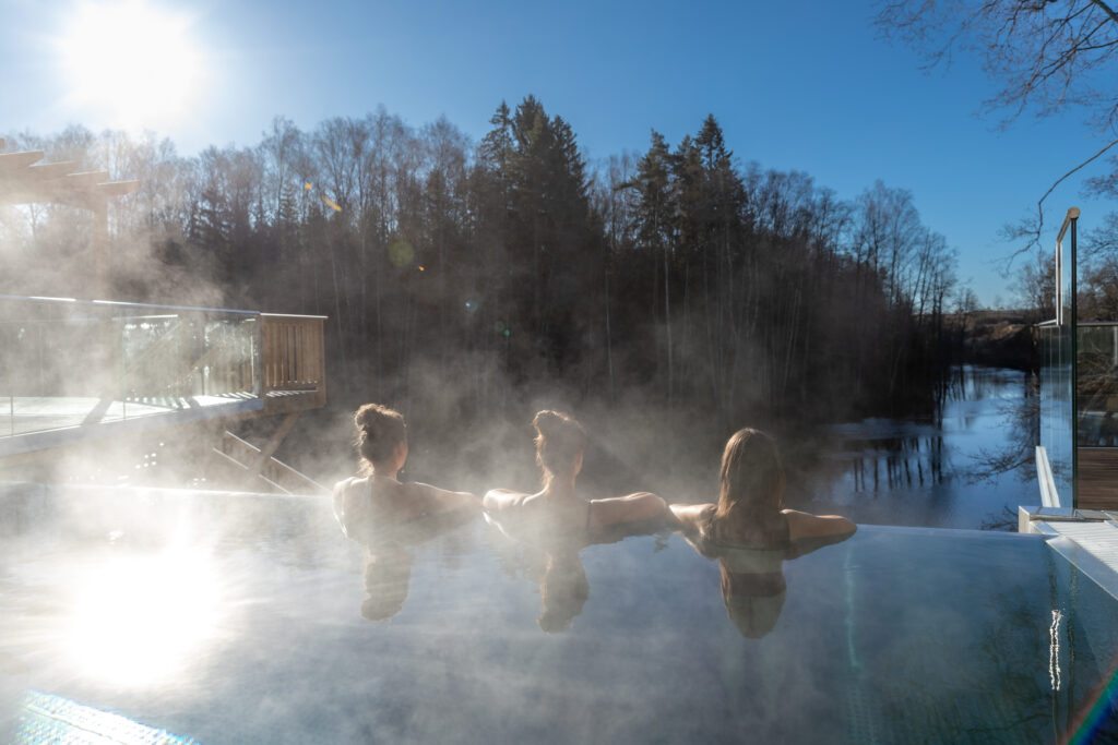 Tre kvinnor med vårt julbord & spa paket njuter av infinitypoolen en kall vintermorgon på Riverside Spa med utsikt över Nissan.